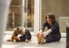 Imagem mostra mãe e filha fazendo alongamento sentadas no chão para ilustrar matéria sobre como manter a rotina de exercícios das crianças na quarentena.