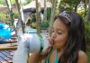 Garota de maiô no jardim brinca com brinquedo reciclado, uma máquina de fazer espuma
