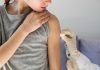 Imagem mostra braço de enfermeira passando algodão em braço de criança para vaciná-la. Seguir o calendário vacinal é essencial para evitar que as crianças contraiam doenças e mantenham a saúde em dia.