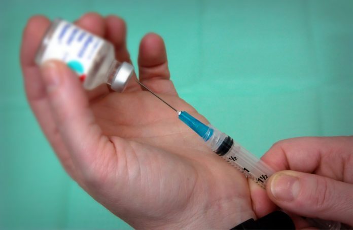 Mãos seguram seringa de vacina para ilustrar matéria sobre risco de coronavírus atrapalhar a vacinação contra o sarampo.