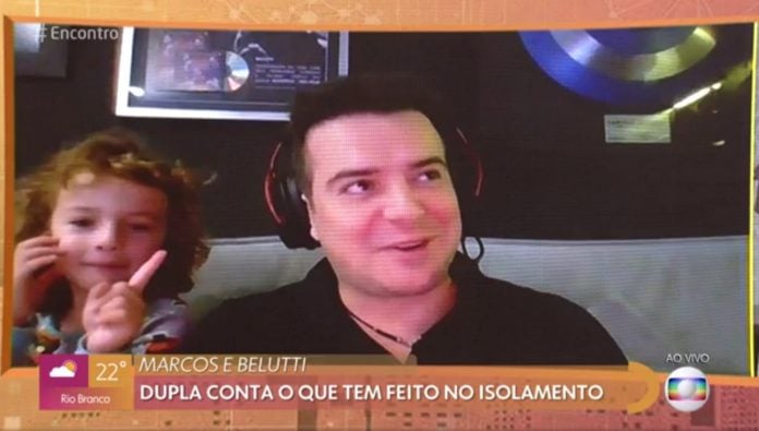 Belutti, da dupla com Marcos, e seu filho em entrevista à Rede Globo; eles ilustram matéria sobre crianças que invadem vídeos dos pais.