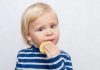 Alimentos azedos e amargos como o limão, que a criança loirinha está chupando nesta imagem, devem ser introduzidas na dieta da criança desde muito cedo.