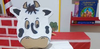 Caixa de supermercado se transforma em vaquinha de papelão banca com manchas pretas e uma luva descartável remete às tetas da vaca para que a criança brinque de tirar leite dela.