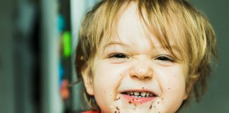 O ganho de peso tem sido observado em crianças durante a quarentena. A falta de atividade física e a tendência a comer mais, como esta criança da foto que come sorridente, prejudicam a saúde dos pequenos.