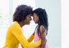Estilo de parentalidade dos pais define características dos filhos na vida adulta. Na foto, mãe e filha negras se olham de bem perto, com as testas encostadas uma na outra.