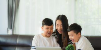 Mãe e crianças olham o computador; imagem ilustra matéria sobre webinários com brincadeiras educativas para a quarentena.