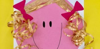Usar a tesoura ajuda a criança a aduqirir habilidades motoras e isso pode ser feito por meio de birncadeiras como esta da imagem, que mostra um desenho de boneca em papel colorido e com cabelos recortados feitos de fitilho.,