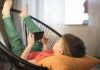 Tempo dedicado às telas, como o garoto desta imagem que assiste algo pelo celular deitado em uma cadeira, é alvo de mais um alerta da Sociedade Brasileira de Pediatria