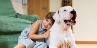 Criança abraça um cachorro; imagem ilustra matéria sobre pesquisa que concluiu que crianças podem ter benefícios ao conviverem com um cachorro.