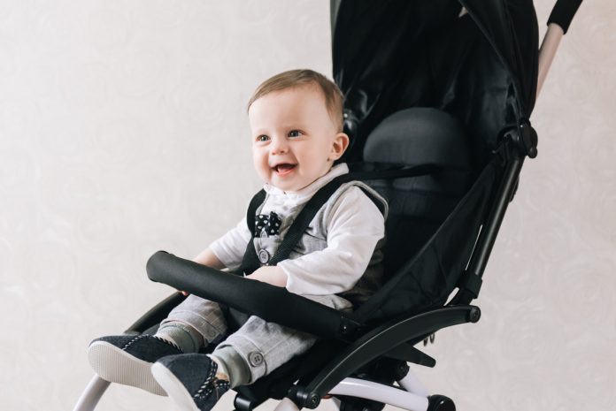 Carrinho de bebê: os 5 mais vendidos do mercado; imagem mostra bebê sentado em carrinho preto