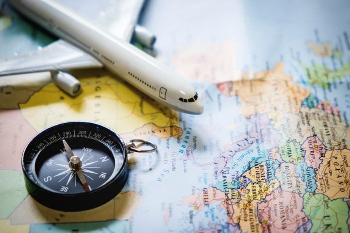 Viagem em família: Imagem mostra mapa mundi, um avião de brinquedo e uma bússola