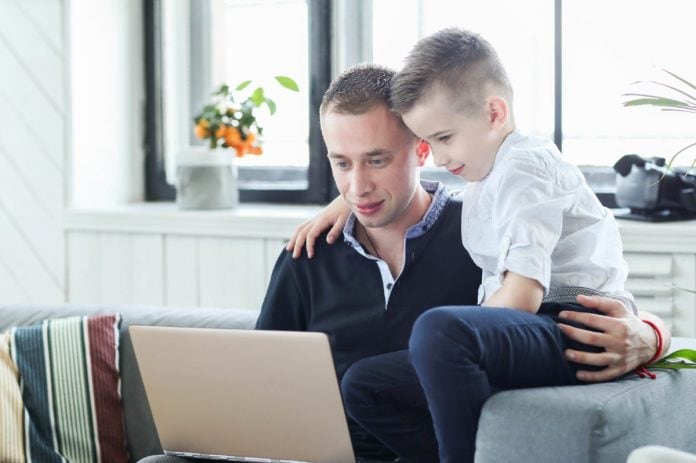 Pai e filho usando um notebook juntos, em ilustração à matéria sobre a importância da supervisão dos pais quando as crianças estão na internet.