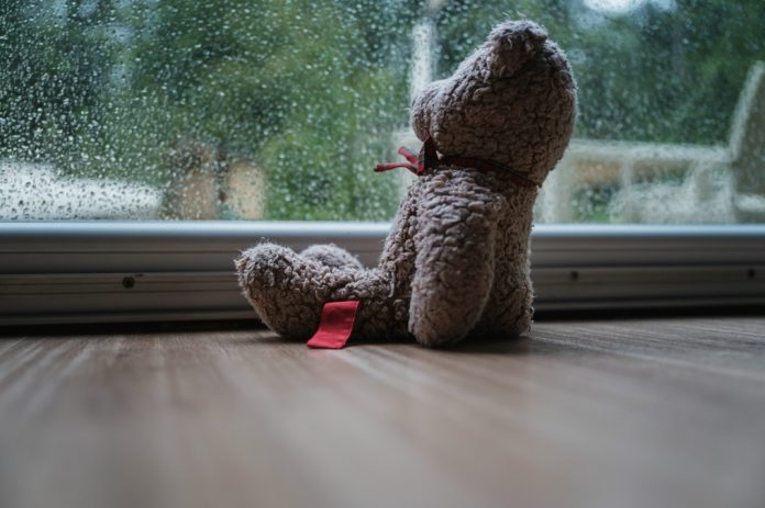 Abuso sexual em crianças: como identificar a prática; imagem mostra urso de pelúcia sentando em frente a uma janela