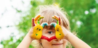 É preciso estimular as crianças a se tornarem empreendedoras; imagem mostra menina que faz um coração com as mãos que estão pintadas coloridas