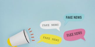 Fake news não deve ser replicada de modo irresponsável em grupo de pais da escola; na imagem uma pessoa segura o celular que mostra na tela as palavras