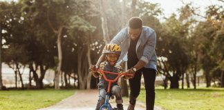 Papel dos pais na criação dos filhos é essencial e traz benefícios aos próprios pais, na imagem pai ajuda o filho a andar de bicicleta