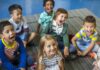 A educação de qualidade está chegando a todos?; imagem mostra 6 crianças em idade pré-escolar olhando para a frente e o alto, algumas de boca aberta gritando