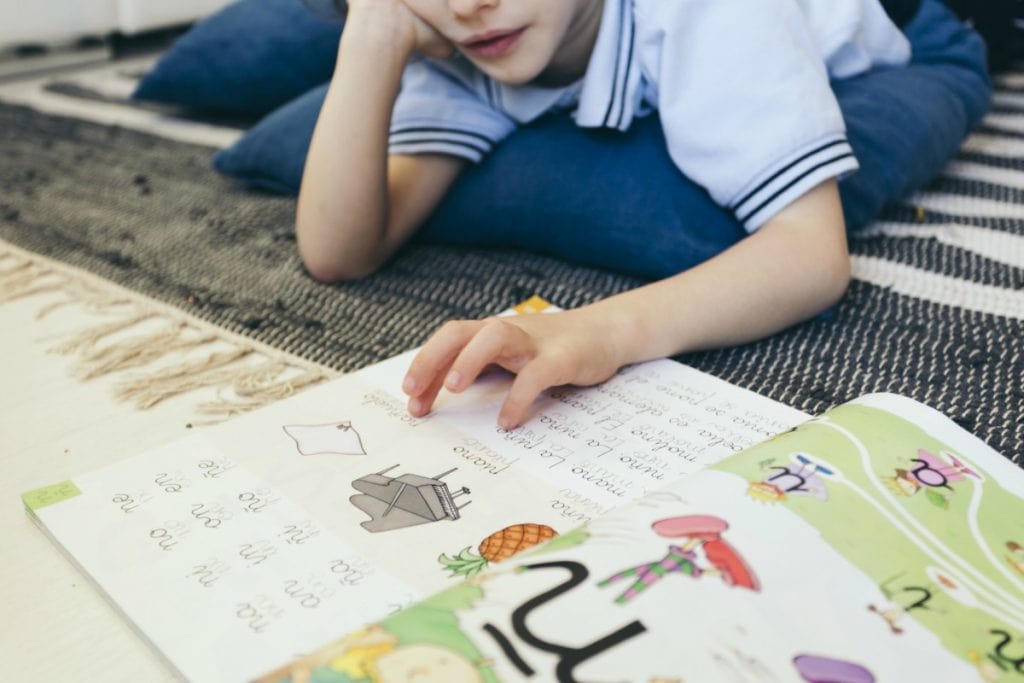 Dia da alfabetização: mais da metade das crianças não sabe ler; na imagem, menino passa dedo sobre letras em livro
