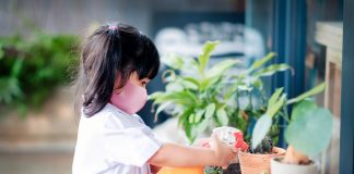 É preciso reabrir as escolas e aprender como elas funcionam, diz diretor de Fundação Lemann; imagem mostra garotinha de máscara regando plantas
