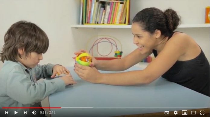Autismo: vídeos ensinam pais a estimular filhos com o transtorno; imagem mostra frame de um dos vídeos em que profissional atende criança autista