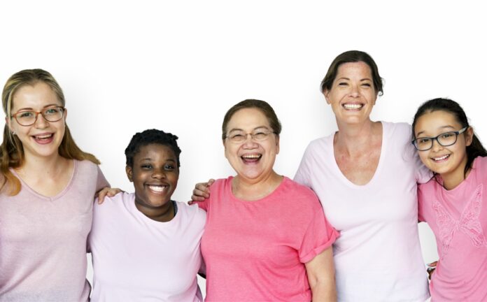 Câncer de mama: 8 dicas para seguir um estilo de vida saudável; imagem mostra 5 mulheres sorridentes vestidas com camisetas em tons de rosa