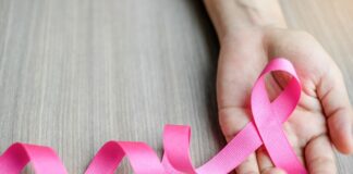 Diagnóstico de câncer de mama: Bebel Soares fala dos medos (e da coragem) para enfrentar um câncer de mama; imagem mostra fitinha rosa em círculos sobre mão