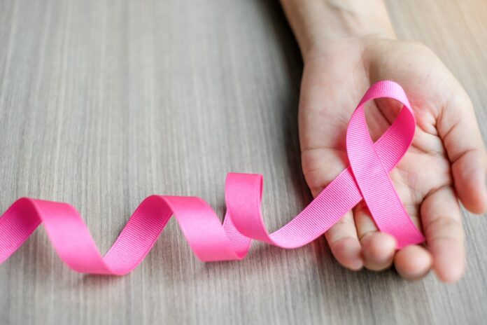 Diagnóstico de câncer de mama: Bebel Soares fala dos medos (e da coragem) para enfrentar um câncer de mama; imagem mostra fitinha rosa em círculos sobre mão