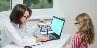 O alerta sobre os exames de imagem em crianças; na imagem, dentista mostra raio-x da boca para criança