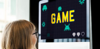 Menino olhando para um computador com um jogo, que pode ser usado como forma de gamificação na educação