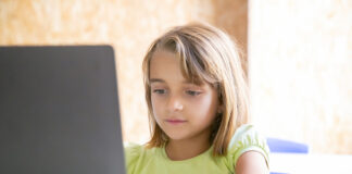Terapia infantil: saiba como ela funciona e quais seus benefícios; imagem mostra menina no computador
