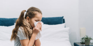 Rinite e conjuntivite alérgicas nas crianças: veja os cuidados a tomar; imagem mostra menina assoando o nariz com papel branco