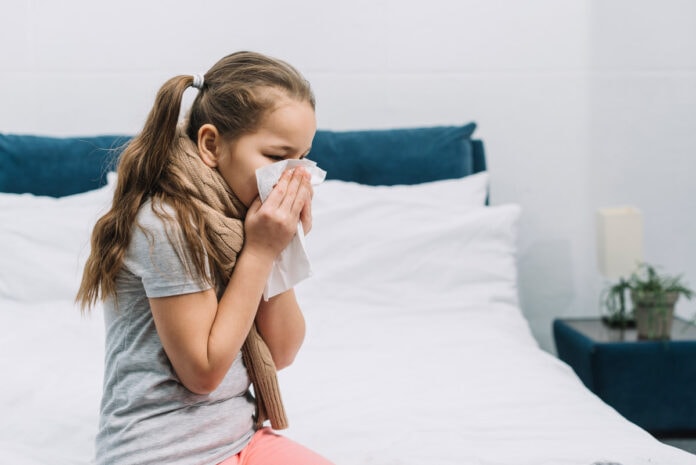 Rinite e conjuntivite alérgicas nas crianças: veja os cuidados a tomar; imagem mostra menina assoando o nariz com papel branco