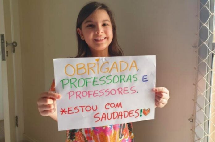 Unicef promove 'obrigadaço' para educadores nas redes sociais; na foto reproduzida pelas redes sociais do Unicef aparece Marina Leon, 8 anos, de Brasília, segurando um cartaz que diz 'Obrigada professoras e professores, estou com saudades