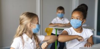 Crianças de máscara em escola em SP