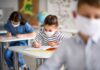 Pediatras assinam carta de apoio ao retorno das aulas presenciais; Criança na sala de aula com máscara