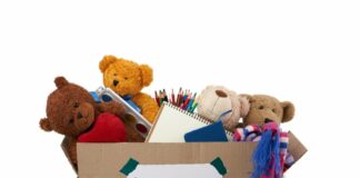 É tempo de doar brinquedos junto com as crianças; imagem mostra caixa de papelão com ursos de pelúcia dentro e materiais de escola