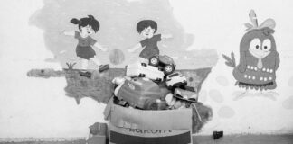 As alterações emocionais de crianças na pré-escola; imagem mostra caixa com brinquedos e parede ao fundo com ilustração infantil