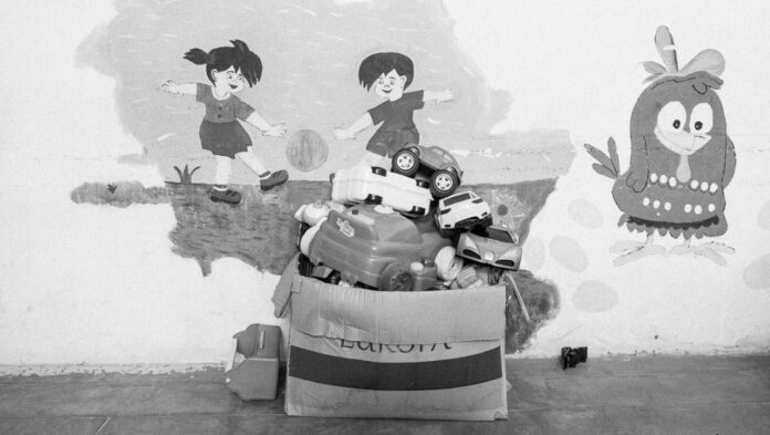 As alterações emocionais de crianças na pré-escola; imagem mostra caixa com brinquedos e parede ao fundo com ilustração infantil