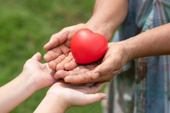 10 instituições que merecem doações da sua família; imagem mostra adulto dando coração para criança