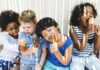 Como falar sobre racismo com as criancas: 5 atitudes a seguir; imagem mostra quatro crianças sentadas tomando sorvete, sendo duas delas negras, um loiro e outro oriental