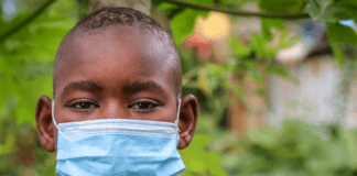 81% das crianças enfrentaram violência desde o início da pandemia; Menino triste de máscara