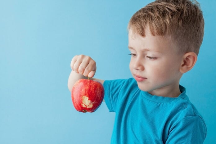 8 formas de ajudar as crianças a experimentar novos alimentos; menino segurando maçã
