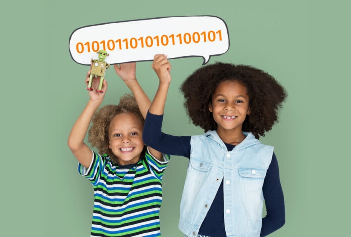 Sistema binário natalino: como ensinar às crianças a linguagem do computador; duas meninas seguram um balão que contem uam sequência de números com 0 e 1