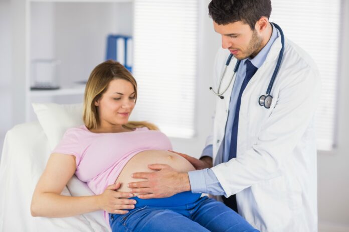 Saiba como a covid-19 pode afetar a gestação – e veja cuidados a tomar; ; médico examina barriga de grávida que está deitada na maca
