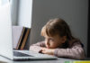 'Geração covid-19': os efeitos da quarentena no desenvolvimento infantil; menina entediada olhando para tela do notebook