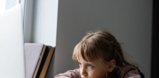 'Geração covid-19': os efeitos da quarentena no desenvolvimento infantil; menina entediada olhando para tela do notebook