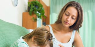 3 atitudes tóxicas que contaminam o ambiente familiar; mãe olha para filho que está de cabeça baixa no sofá