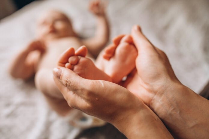 Capacitação de obstetrizes pode salvar 4,3 milhões de vidas no mundo, diz OMS; mãos de adulto seguram pés de recém-nascido