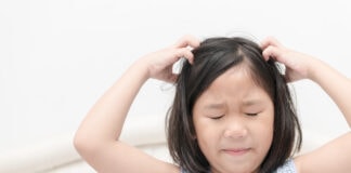 Piolhos em crianças: conheça os riscos e tratamentos; Menina coçando o cabelo com as mãos