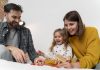 5 necessidades emocionais que os pais devem atender nas crianças; pai e mãe brincam com criança que mexe em brinquedo